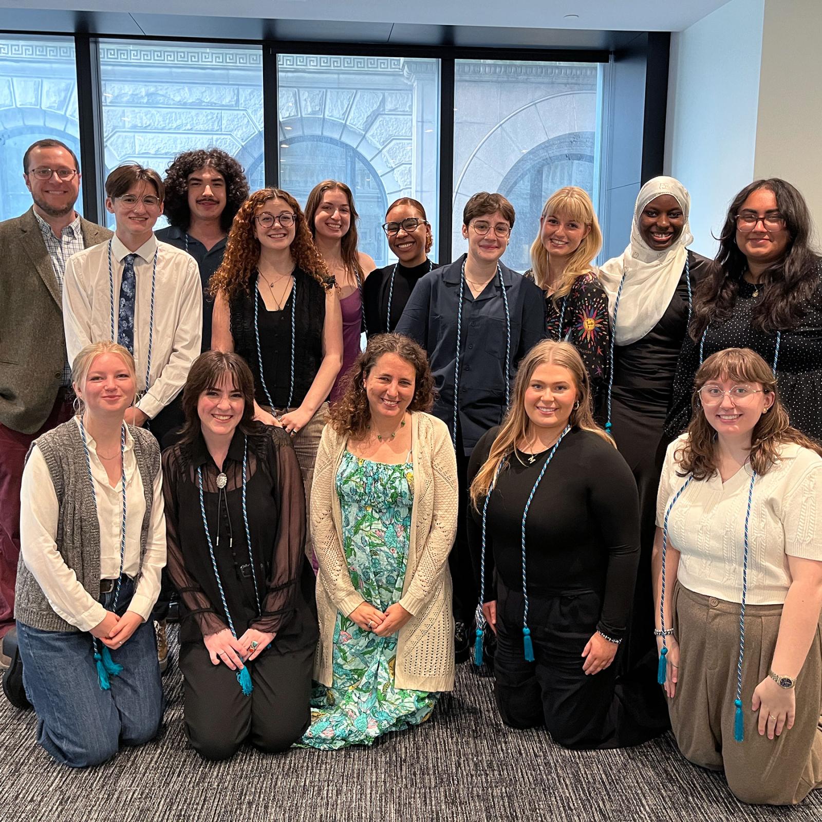 Pace University Peace and Justice Studies students and faculty in two rows in front of a window