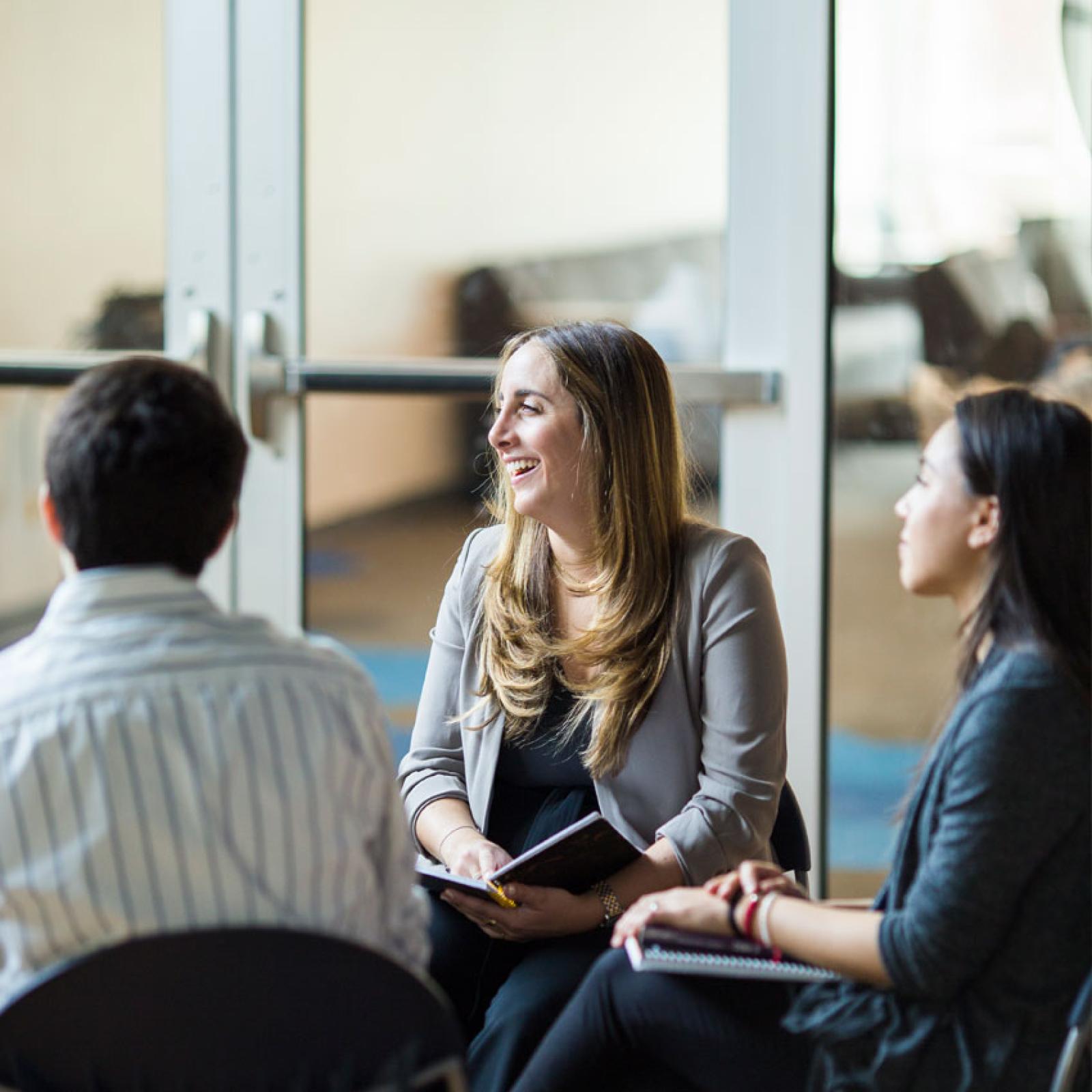 A group of young professionals talking on the Pleasantville Campus of Pace University.