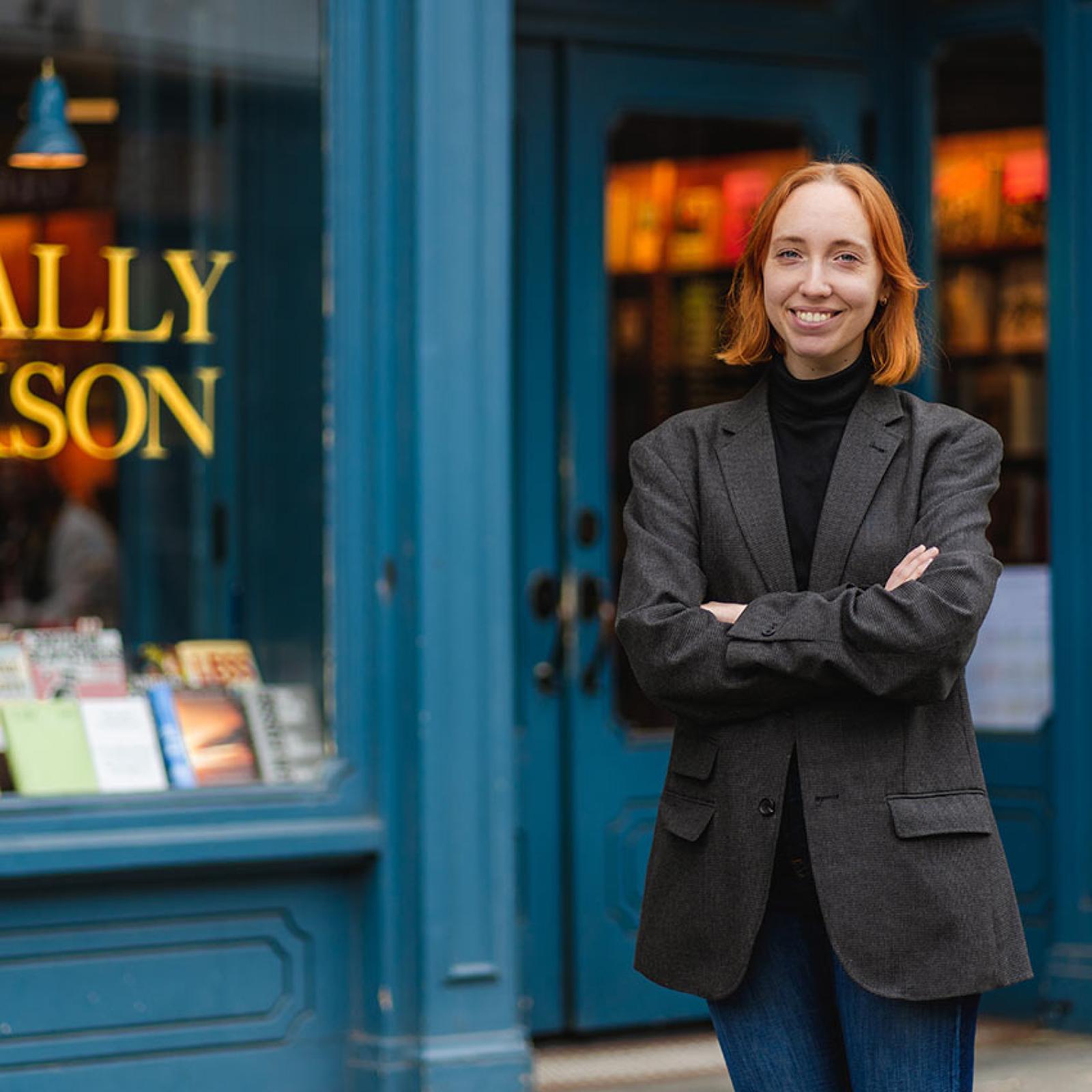 A Pace University publishing student stands outside of a book store.