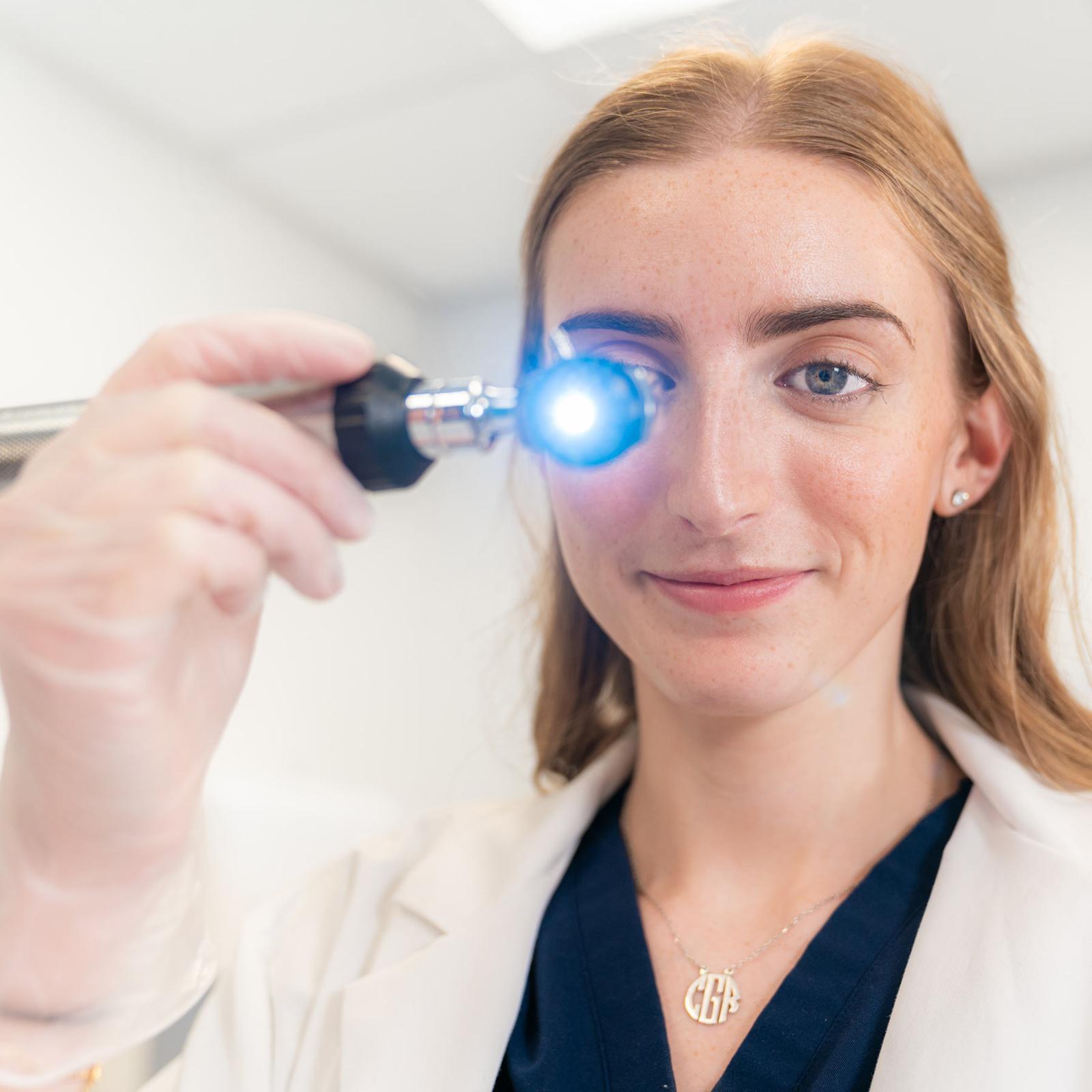 Pace University Physician Assistant Studies student using an otoscope