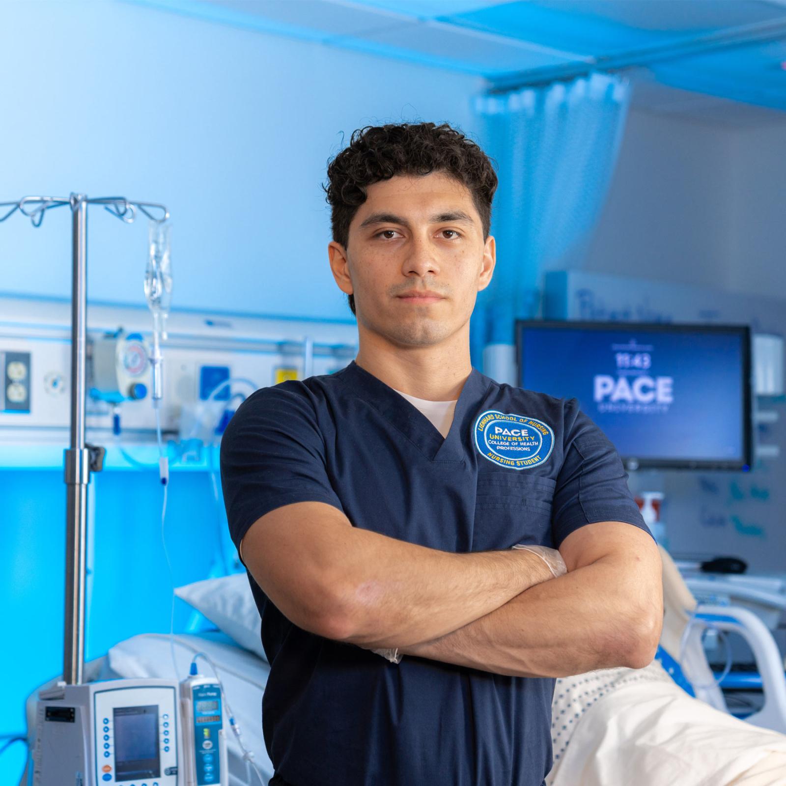 A Pace nursing student standing in the sim lab and posing for the camera. 