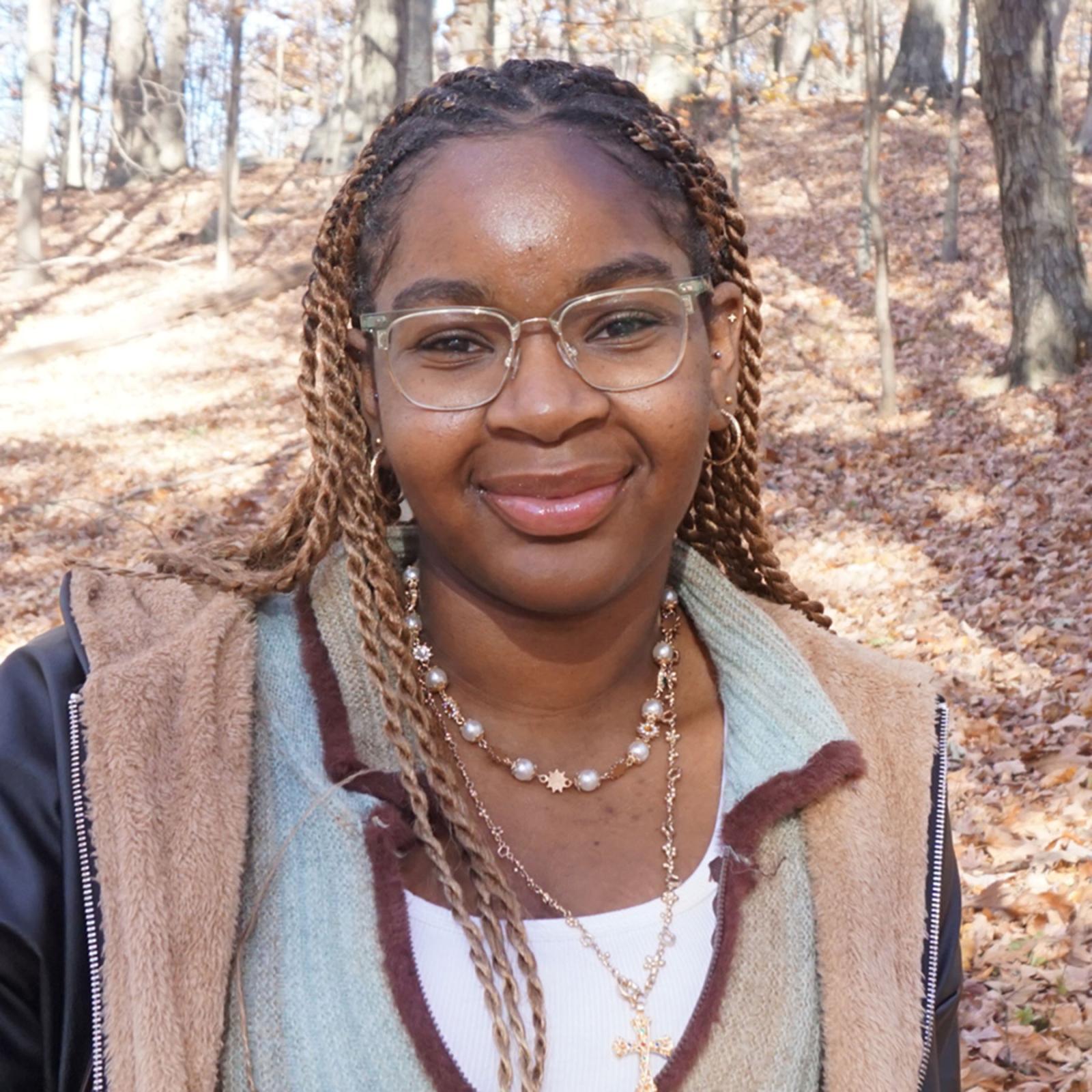 Pace University Economics student Shaniah James with leaves behind her