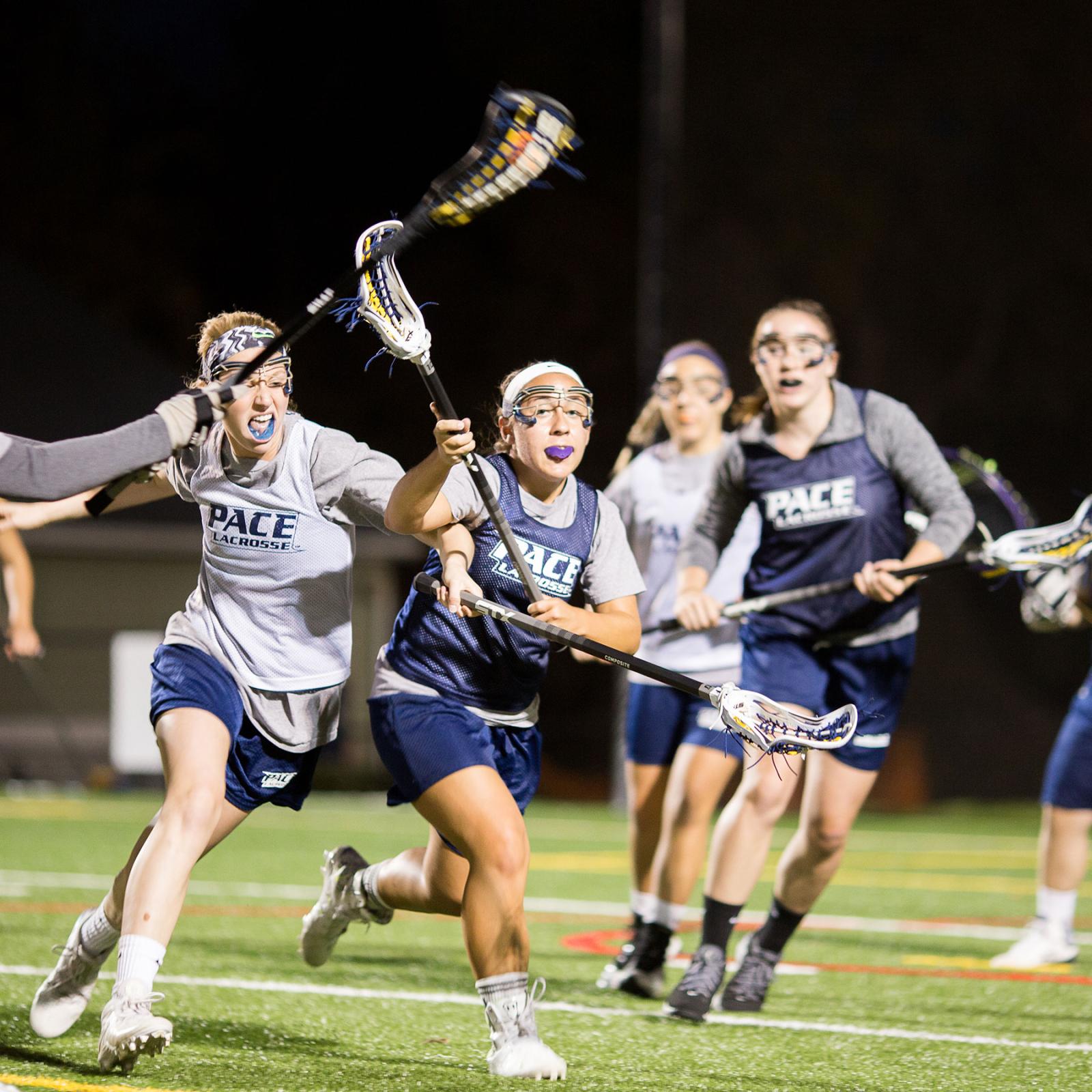 Pace University female lacrosse players playing in a game.