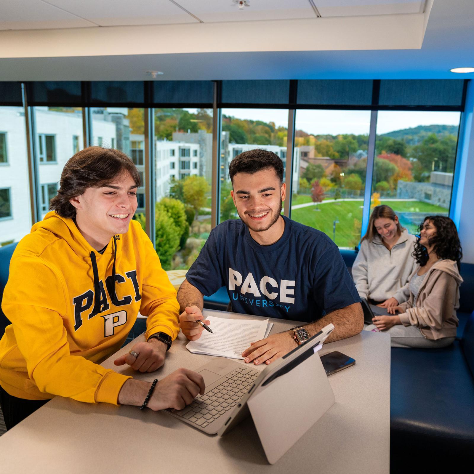 Group of Pace University students sitting in a common area, studying and talking on the Wescthester campus.